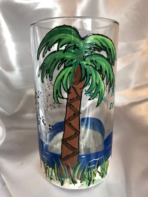 Palm tree design on It's 5 o'clock somewhere beer mug- with raised outlining, beige sand, green grasses, blue ocean with waves- details in raised outlining