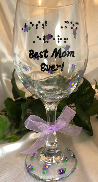 Wine Glass with words: Best Mom Ever! in braille and script. Hand painted purple violets with green leaves all around the glass and on the base