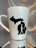 White mug with MCBVI Logo- a silhouette of the entire state of Michigan in black, person with cane